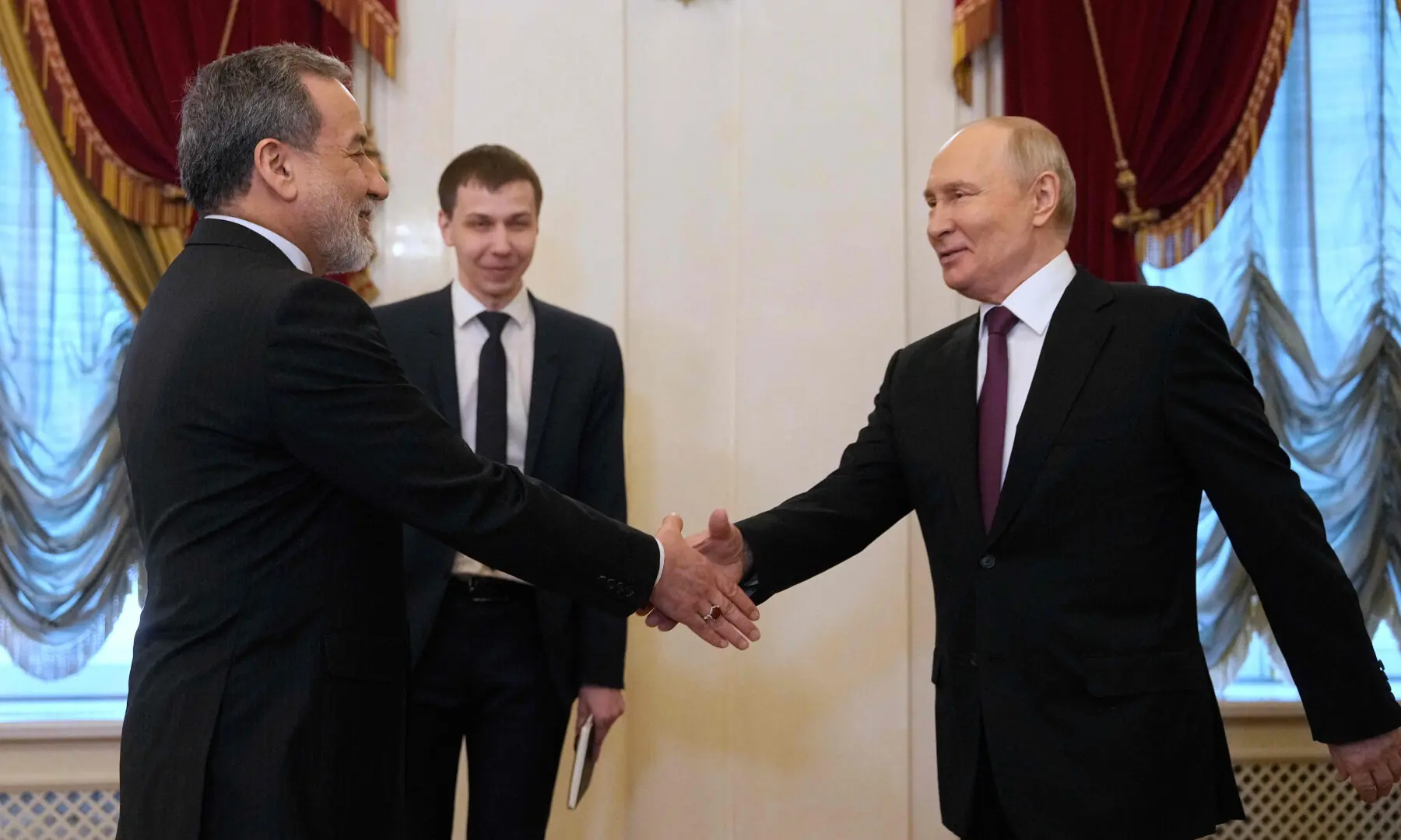 Russian President Vladimir Putin shakes hands with Iranian Foreign Minister Abbas Araghchi at the Boris Yeltsin Presidential Library in St. Petersburg on April 27, 2026, as Moscow reaffirms its strategic partnership with Tehran amid stalled US-Iran ceasefire negotiations. (AFP / Dawn)